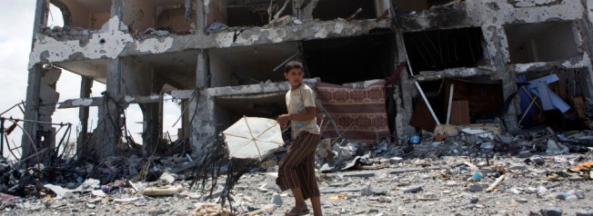 A Palestinian child withn a kite in front of the destroyed Al-Nada towers in Beit Hanoun, North Gaza, August 4, 2014. The towers had 90 flats. So far, Israeli attacks have killed at least 1,870 Palestinians, and injured 9470 since the beginning of the Israeli offensive.